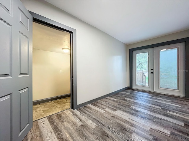 empty room with wood-type flooring and french doors