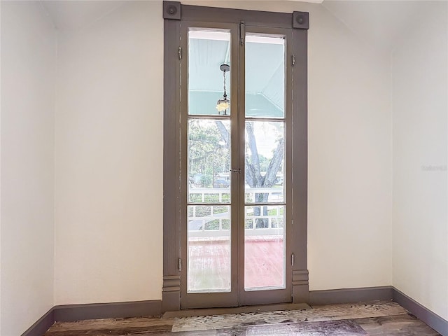 doorway featuring hardwood / wood-style flooring and vaulted ceiling