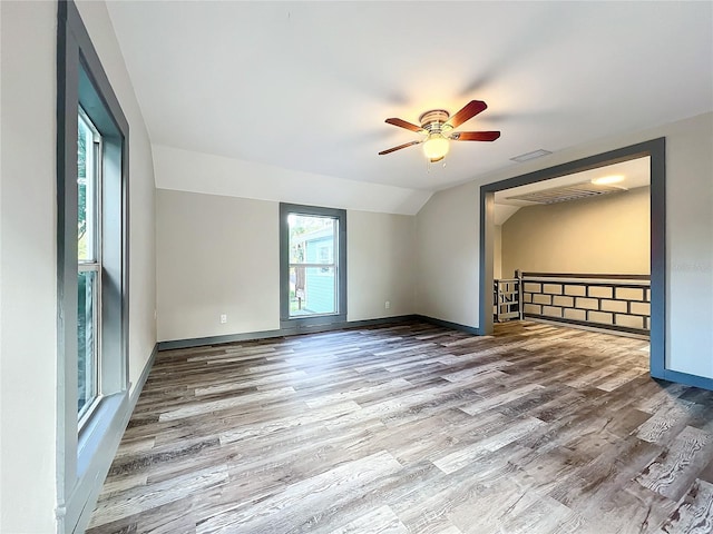 spare room featuring hardwood / wood-style flooring, vaulted ceiling, and ceiling fan