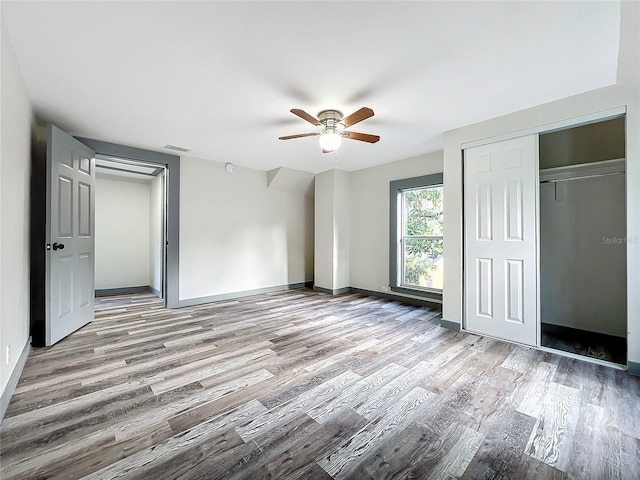 unfurnished bedroom with a closet, wood-type flooring, and ceiling fan