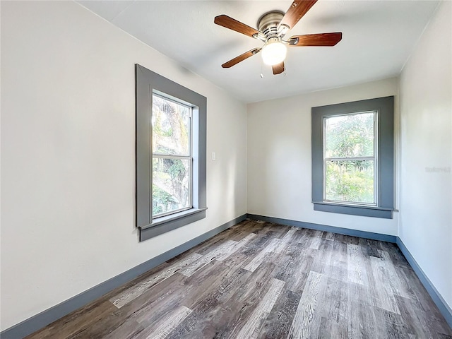 spare room featuring hardwood / wood-style floors, ceiling fan, and plenty of natural light