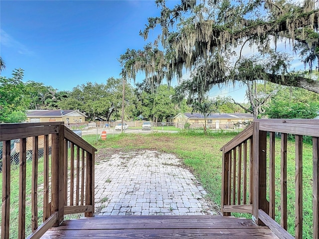 wooden terrace featuring a yard