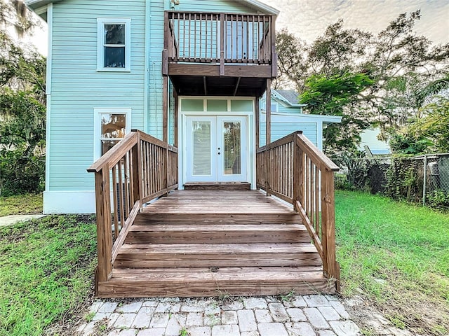 rear view of property with a balcony and french doors