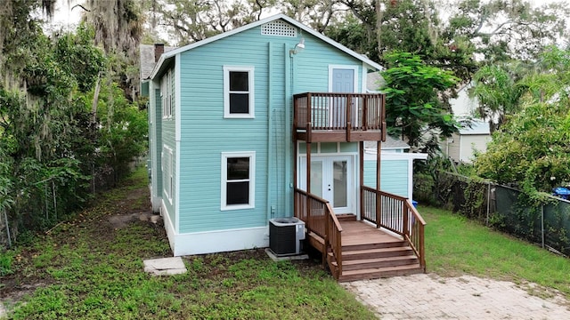 back of property featuring a balcony, central air condition unit, and a yard