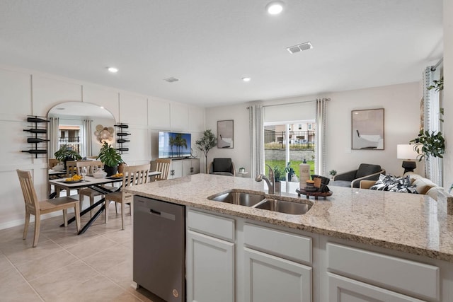 kitchen with sink, dishwasher, light tile patterned floors, and white cabinetry