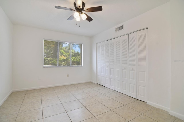 unfurnished bedroom featuring a closet, ceiling fan, and light tile patterned floors