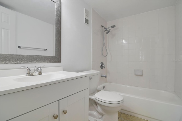 full bathroom with tile patterned floors, vanity, tiled shower / bath combo, and toilet