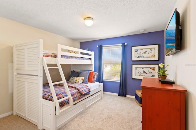 bedroom featuring light colored carpet and a textured ceiling