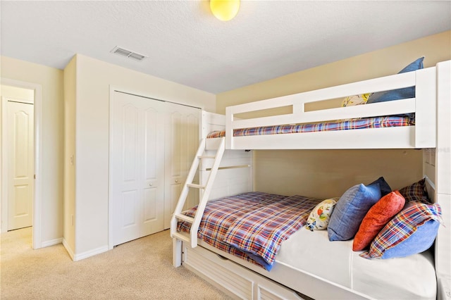 bedroom featuring carpet, a textured ceiling, and a closet