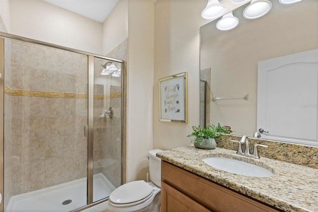 bathroom with vanity, a shower with shower door, and toilet