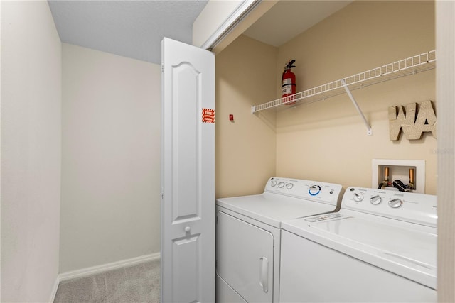 laundry room featuring light colored carpet and washer and clothes dryer