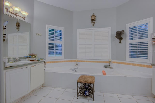 bathroom featuring tile patterned flooring, vanity, and a relaxing tiled tub