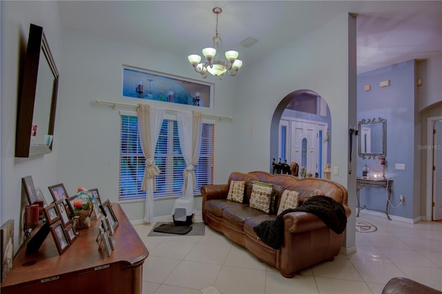 living room featuring a notable chandelier, light tile patterned flooring, and a high ceiling