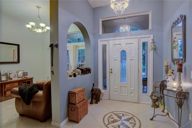 entryway featuring a high ceiling, light tile patterned floors, and an inviting chandelier