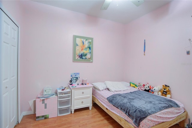 bedroom featuring light hardwood / wood-style floors, ceiling fan, and a closet