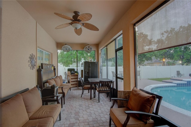 sunroom / solarium with a swimming pool and ceiling fan