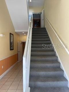 stairs featuring wainscoting and tile patterned flooring