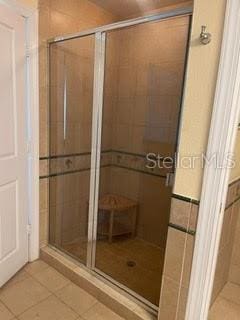 bathroom with a shower with door and tile patterned flooring