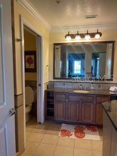 bathroom with vanity, tile patterned flooring, wine cooler, and ornamental molding