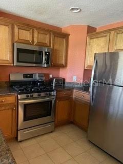 kitchen featuring stainless steel appliances and light tile patterned floors