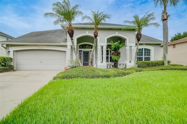 mediterranean / spanish house with a garage and a front yard