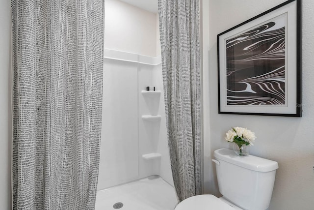 bathroom featuring curtained shower and toilet