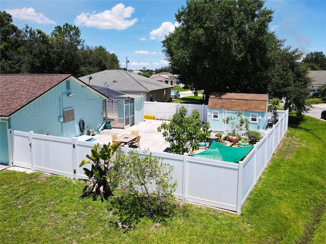 rear view of property with a lawn, a patio area, and an outbuilding