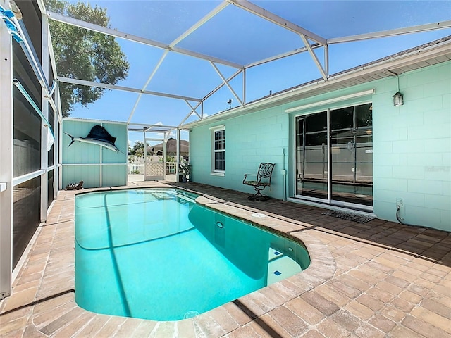 view of swimming pool with glass enclosure and a patio