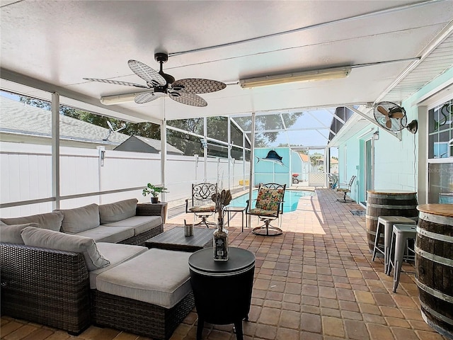 view of patio with outdoor lounge area, glass enclosure, and ceiling fan