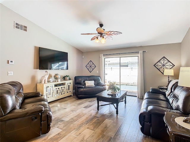 living room featuring ceiling fan, light hardwood / wood-style flooring, and lofted ceiling