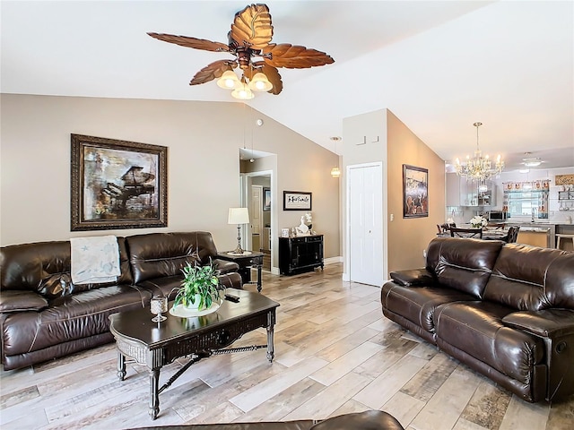 living room featuring ceiling fan with notable chandelier, vaulted ceiling, and light hardwood / wood-style flooring