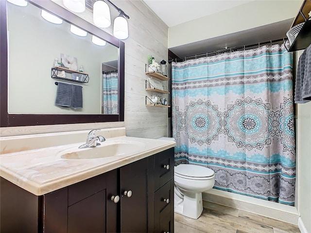 bathroom with hardwood / wood-style floors, vanity, wood walls, and toilet