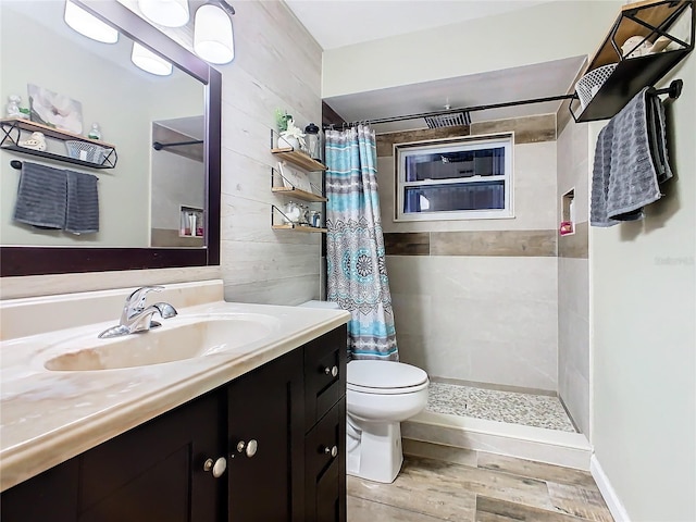 bathroom featuring vanity, wood walls, toilet, walk in shower, and wood-type flooring