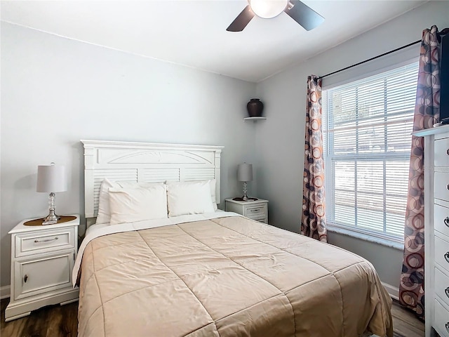 bedroom with multiple windows, ceiling fan, and dark hardwood / wood-style floors