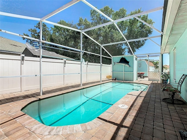 view of swimming pool featuring glass enclosure and a patio area