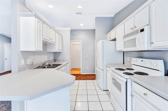 kitchen featuring sink, white appliances, light tile patterned floors, white cabinets, and kitchen peninsula