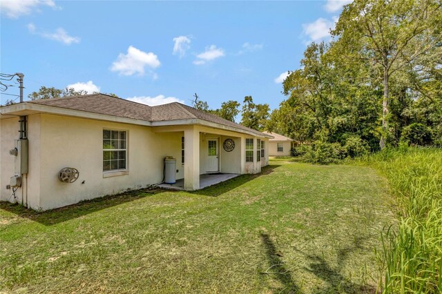 back of house with a yard and a patio area