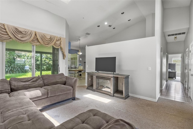 carpeted living room featuring a healthy amount of sunlight and a towering ceiling