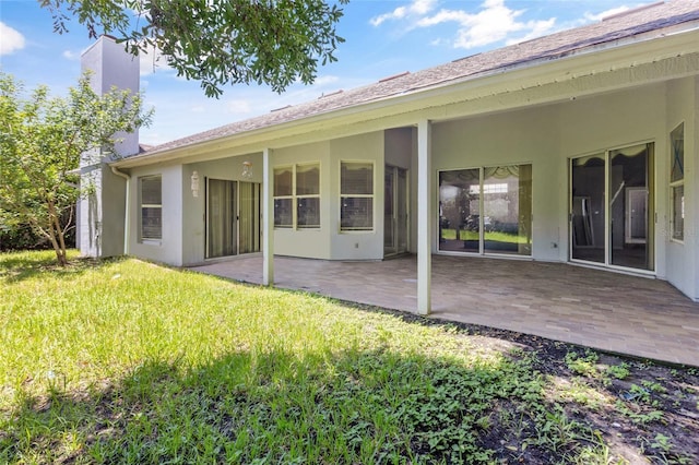 back of house featuring a lawn and a patio