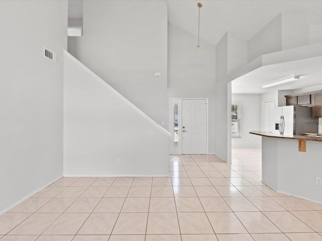 tiled foyer entrance with high vaulted ceiling