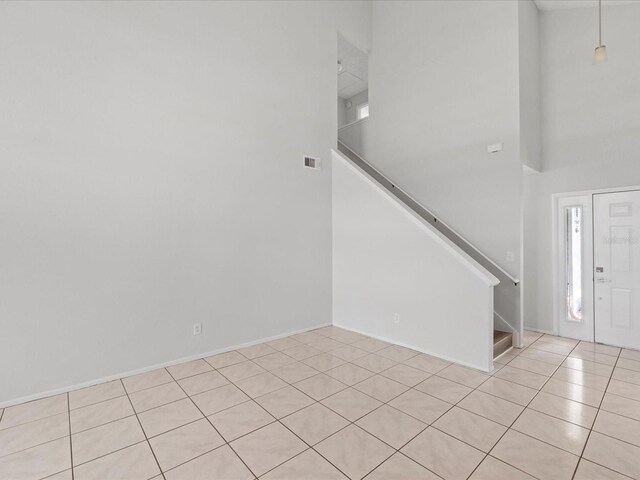 entryway with a high ceiling and light tile patterned floors