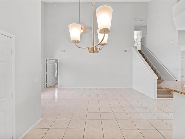 unfurnished room with light tile patterned floors and a towering ceiling