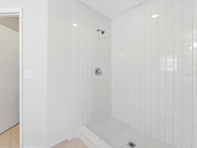 bathroom with a tile shower and tile patterned flooring