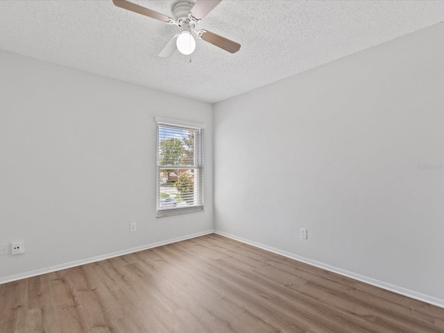 empty room with ceiling fan, light hardwood / wood-style floors, and a textured ceiling