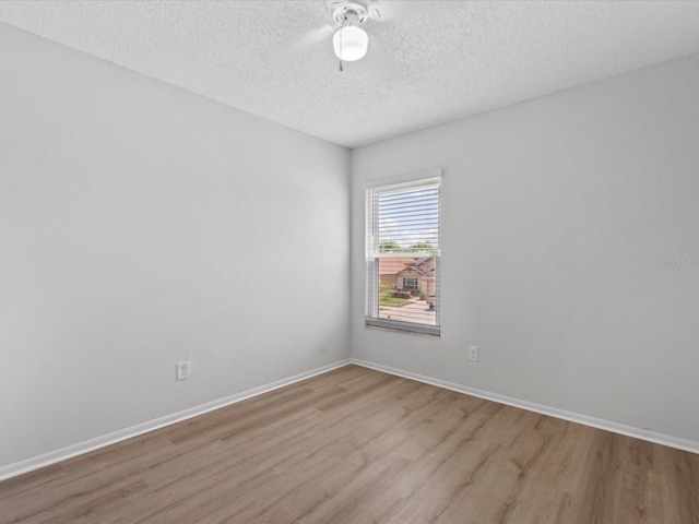 spare room featuring ceiling fan, a textured ceiling, and light wood-type flooring