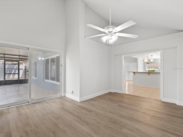 unfurnished living room with wood-type flooring, ceiling fan with notable chandelier, and high vaulted ceiling