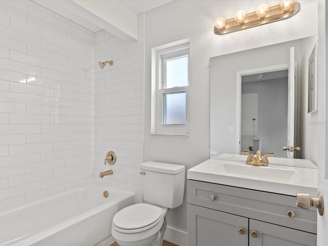 full bathroom featuring tiled shower / bath, vanity, and toilet