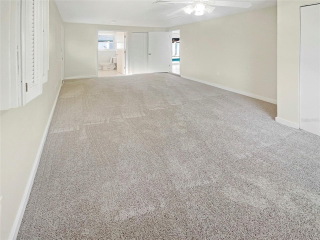 spare room featuring light carpet and ceiling fan