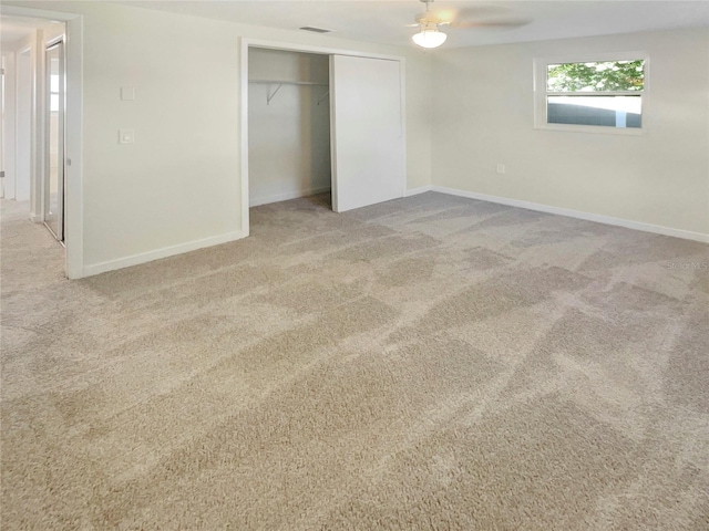 unfurnished bedroom featuring a closet, ceiling fan, and light carpet