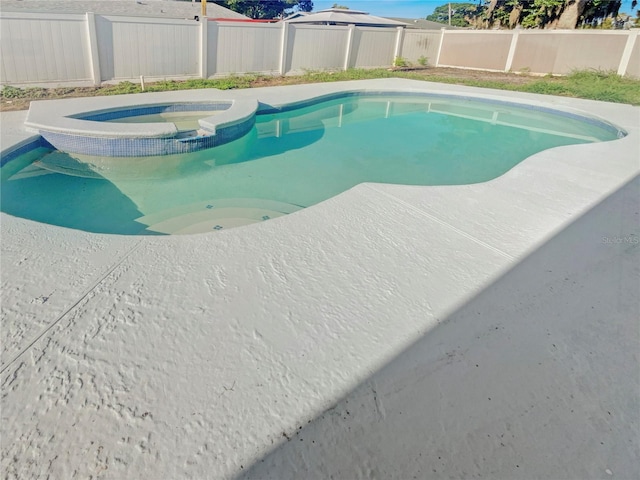 view of pool with an in ground hot tub